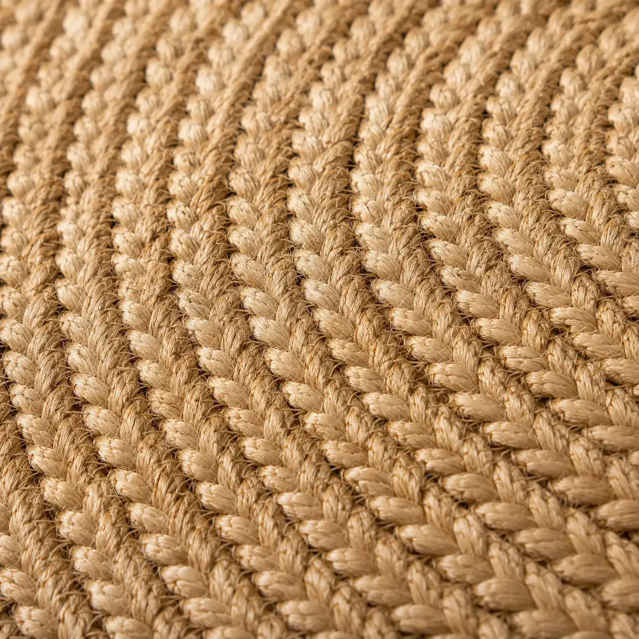 Close-up detail of the Aurelia oval jute rug showing elongated hand-braided natural fibre weave, artisanal texture, and handcrafted construction.
