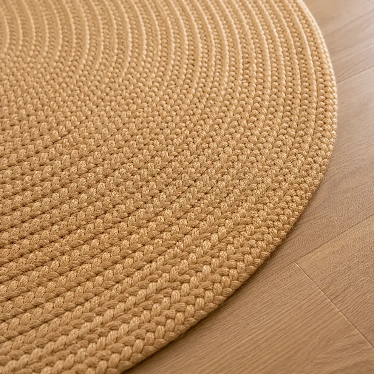 Close-up detail of the Aurelia oval jute rug showing hand-braided edge construction, natural fibre texture, and artisan craftsmanship on oak flooring.